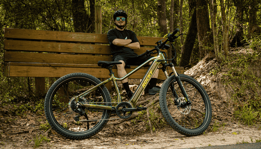 Cyclist taking a break beside an electric bike on a North Texas trail